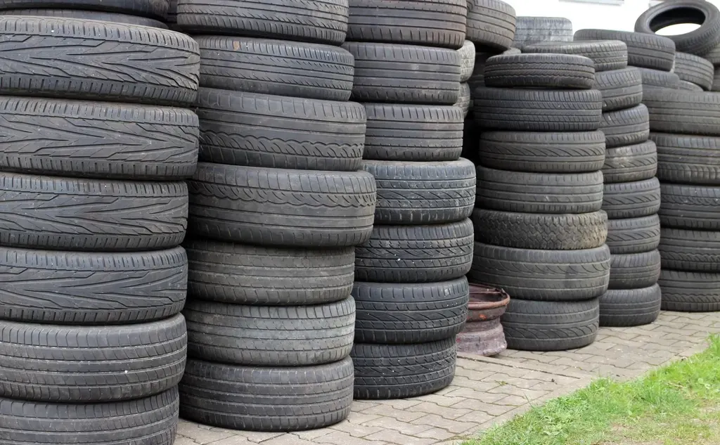 Pneus usagés empilés pour recyclage dans un centre VHU