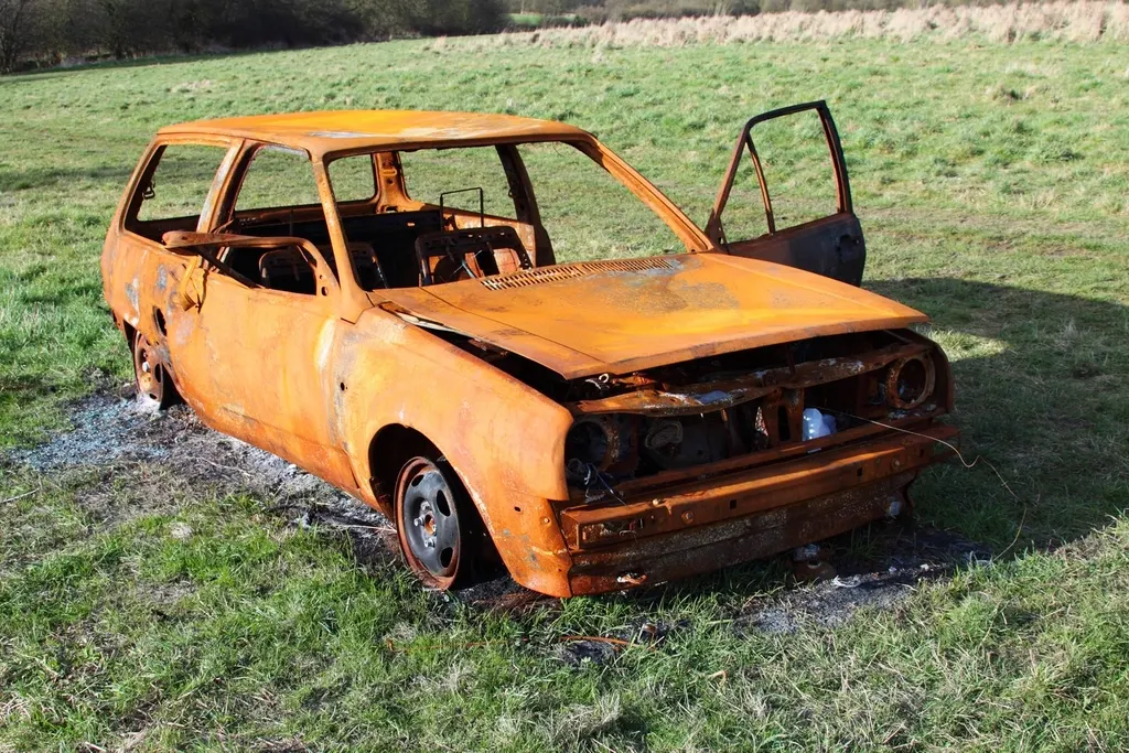 Épave rouillée abandonnée dans l'herbe